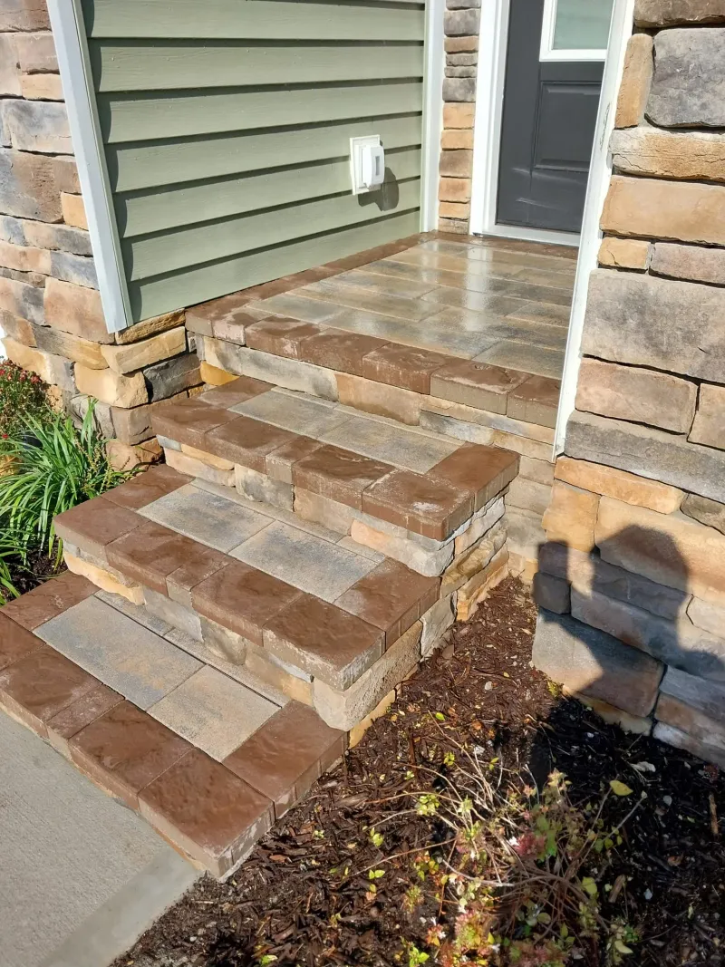 Stone and paver entry steps leading to a front door