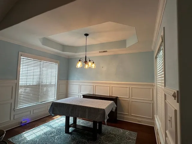 Dining room with wall paneling and hanging light fixture